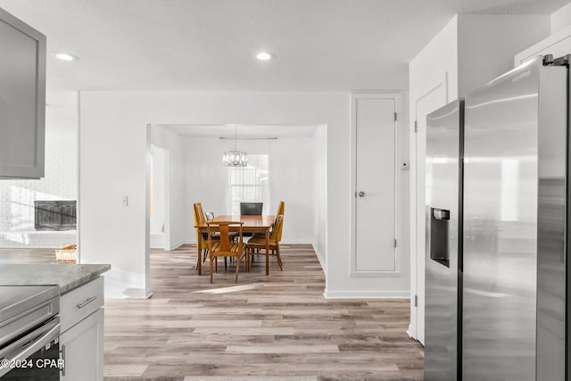 kitchen with gray cabinetry, light hardwood / wood-style floors, and appliances with stainless steel finishes