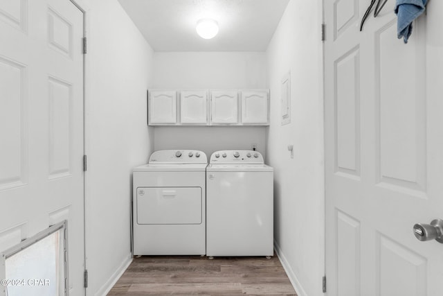 washroom featuring separate washer and dryer, light hardwood / wood-style flooring, and cabinets