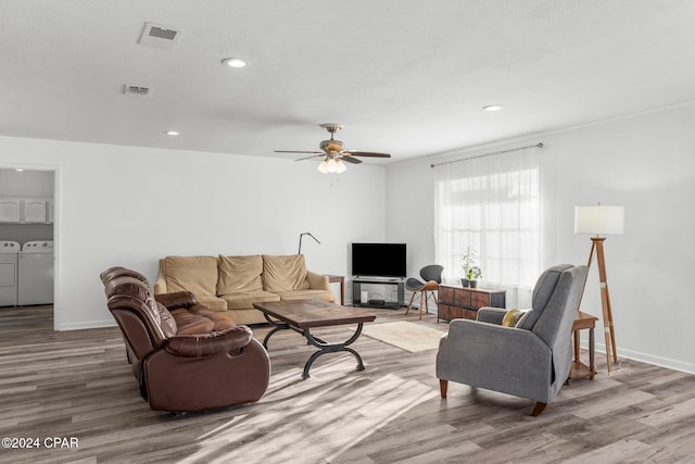 living room with hardwood / wood-style floors, independent washer and dryer, and ceiling fan