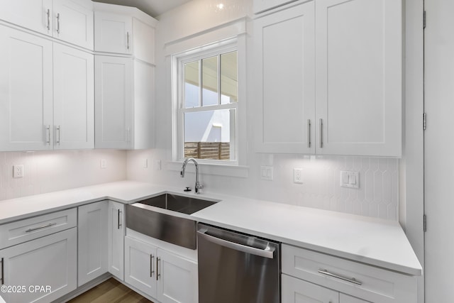 kitchen with a sink, white cabinets, light countertops, backsplash, and dishwasher