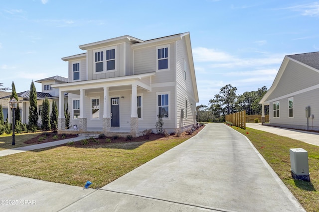 view of front of home with a front lawn, a porch, and board and batten siding