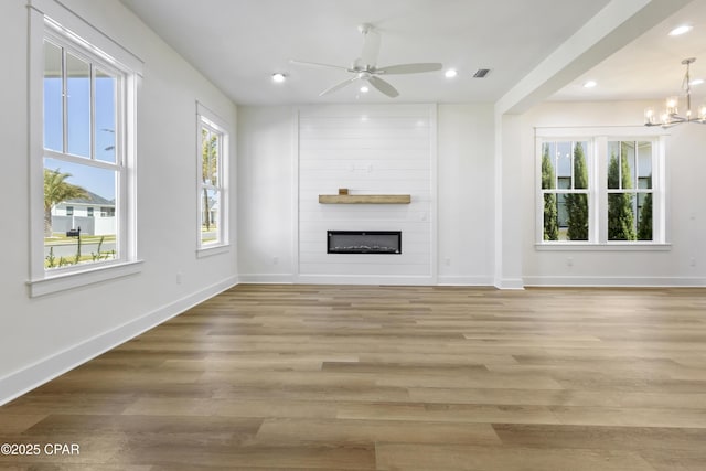 unfurnished living room featuring a large fireplace, recessed lighting, baseboards, and light wood-style floors