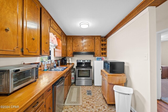 kitchen featuring crown molding, sink, and appliances with stainless steel finishes