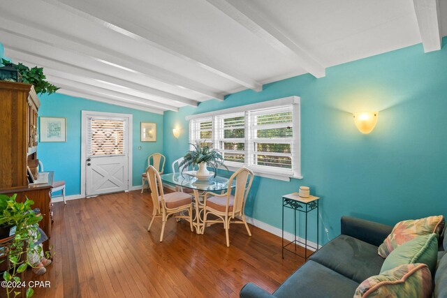 dining room featuring hardwood / wood-style floors and vaulted ceiling with beams