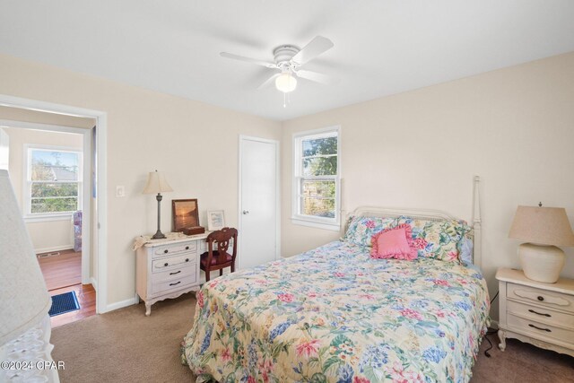 bedroom with ceiling fan, carpet floors, and multiple windows