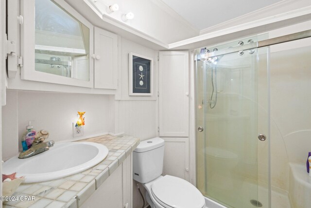 bathroom with vanity, toilet, ornamental molding, and walk in shower