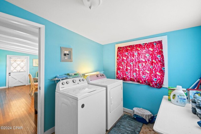 laundry room with wood-type flooring, electric panel, and washing machine and clothes dryer