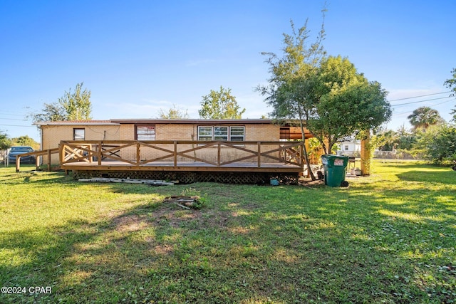 rear view of property featuring a yard and a wooden deck