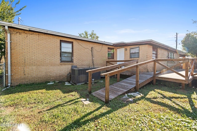 back of house with a lawn, a deck, and central air condition unit