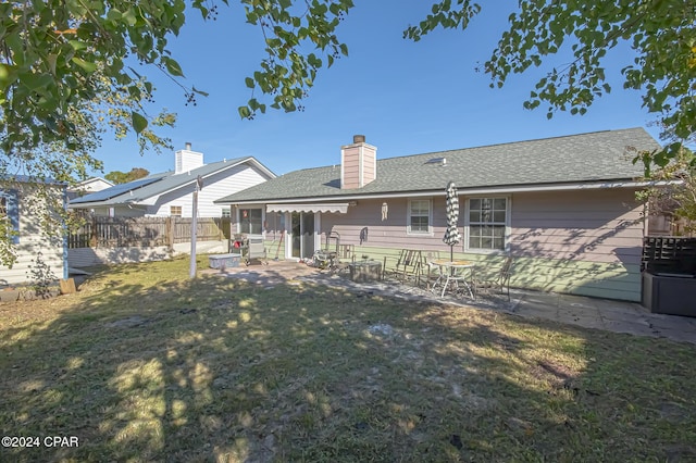 back of property featuring a patio and a lawn