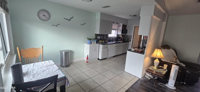 kitchen with white cabinetry, light tile patterned floors, and decorative backsplash