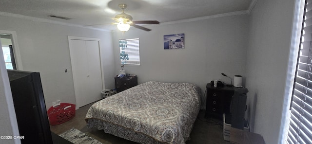 bedroom featuring ceiling fan, ornamental molding, and a closet