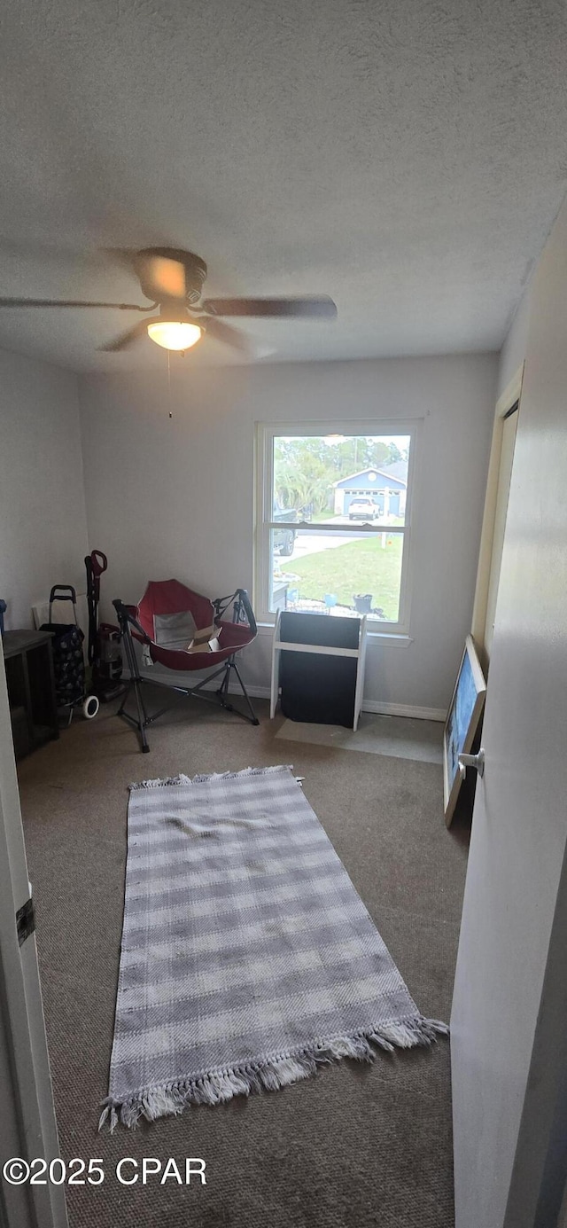 bedroom with ceiling fan, carpet floors, and a textured ceiling