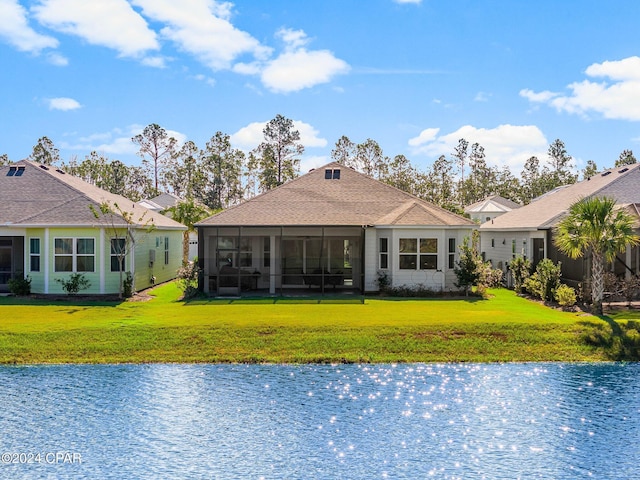 back of house with a lawn, a sunroom, and a water view