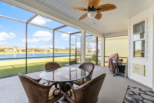 sunroom featuring ceiling fan, a water view, and a wealth of natural light