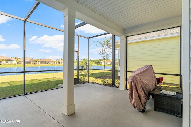 unfurnished sunroom featuring a water view