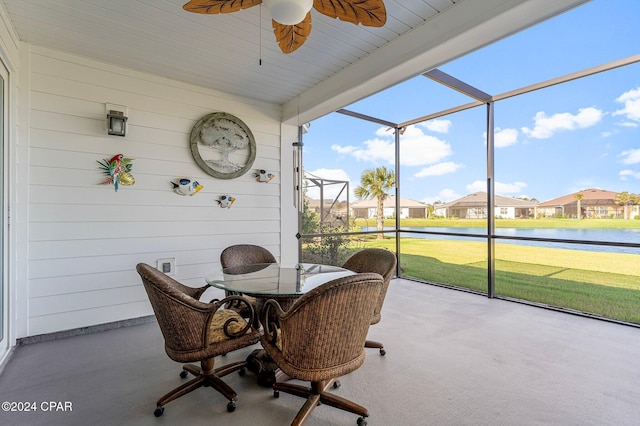 sunroom featuring ceiling fan, plenty of natural light, and a water view