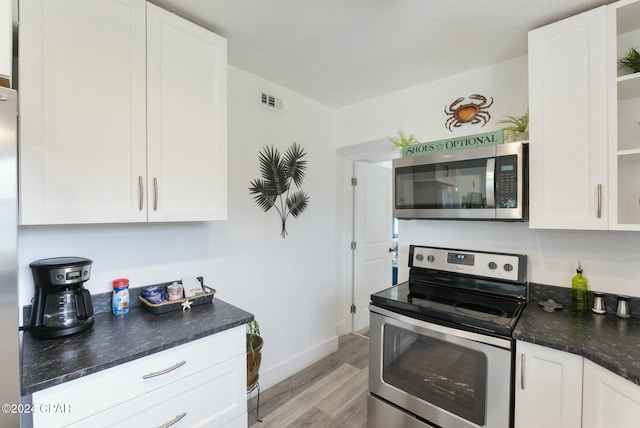 kitchen featuring white cabinets, appliances with stainless steel finishes, and light hardwood / wood-style flooring