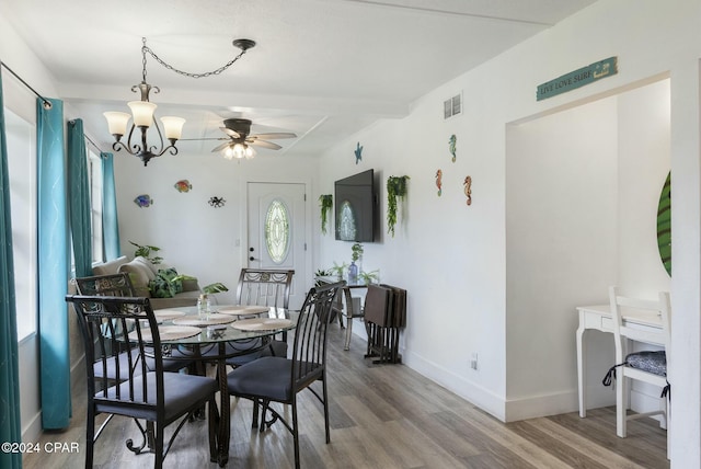 dining space featuring hardwood / wood-style floors and ceiling fan with notable chandelier