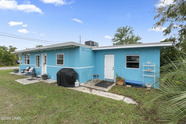 back of property with a yard and cooling unit