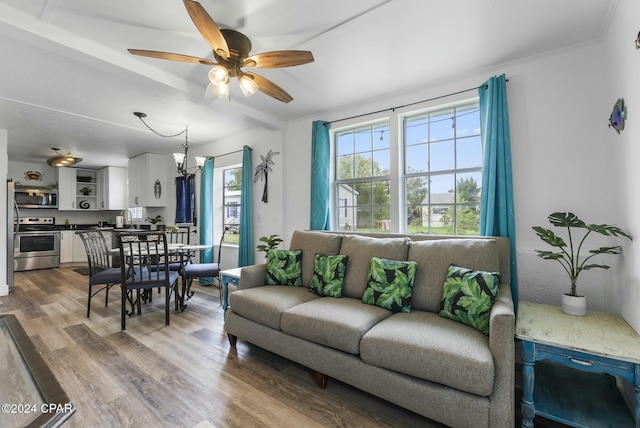 living room with sink, ceiling fan with notable chandelier, and hardwood / wood-style flooring