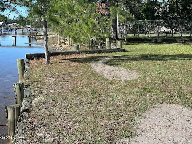 view of yard featuring a water view and a boat dock