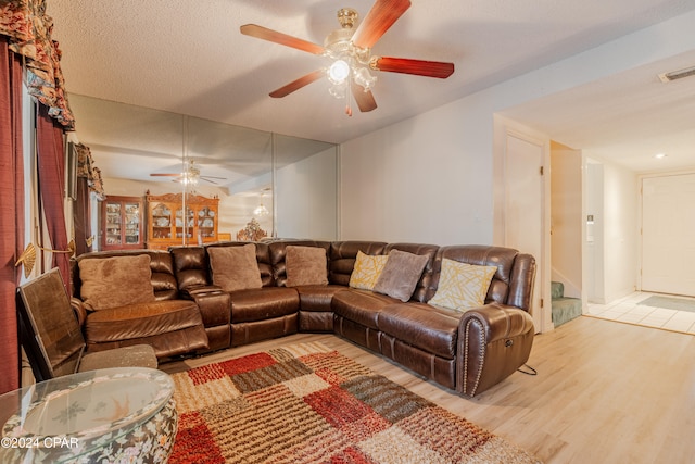 living room with a textured ceiling and light hardwood / wood-style flooring