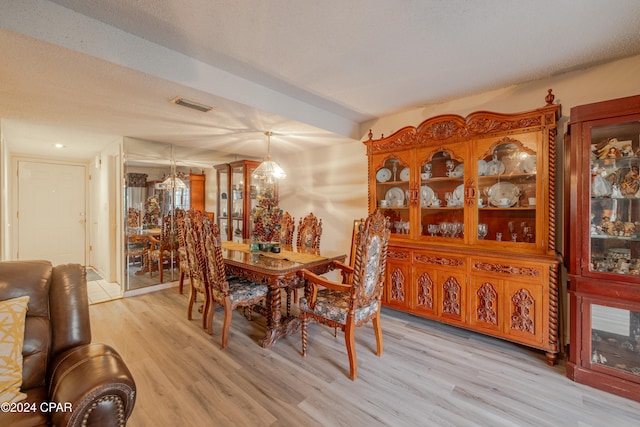 dining room with a textured ceiling and light hardwood / wood-style floors