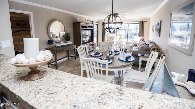 dining room with a textured ceiling, an inviting chandelier, and ornamental molding