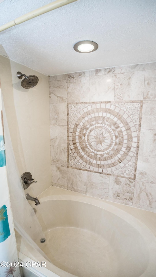 bathroom featuring a textured ceiling and shower / tub combo