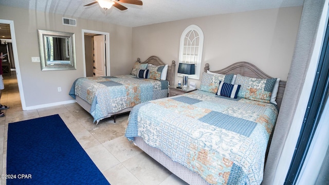 bedroom with light tile patterned floors, a textured ceiling, and ceiling fan