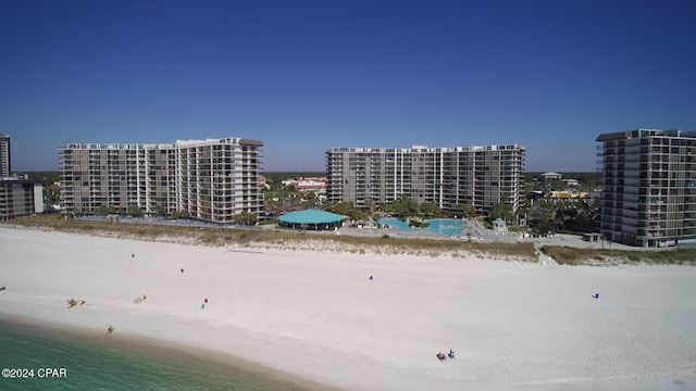 birds eye view of property featuring a water view and a beach view