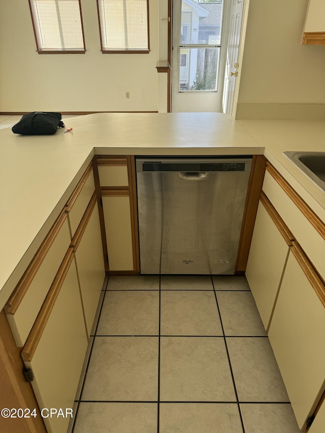 kitchen with light tile patterned floors, kitchen peninsula, and dishwasher