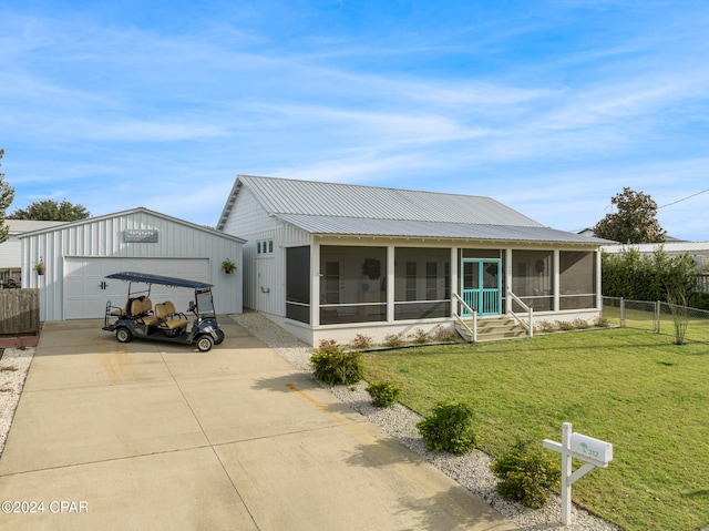 view of front facade featuring a sunroom, a front lawn, an outdoor structure, and a garage