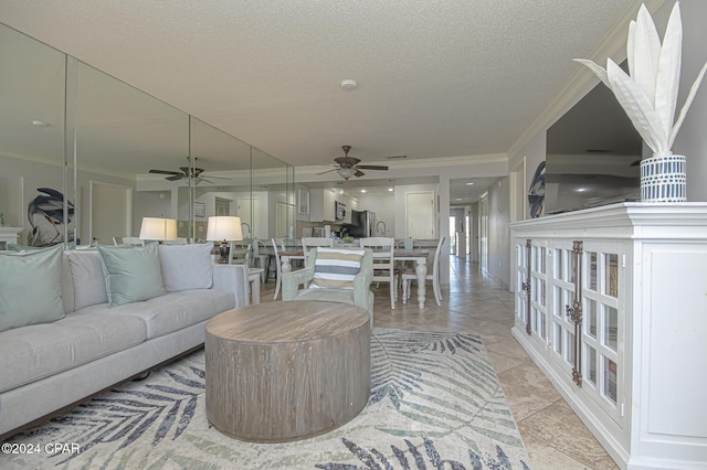 living room featuring light tile patterned floors, ornamental molding, a textured ceiling, and ceiling fan