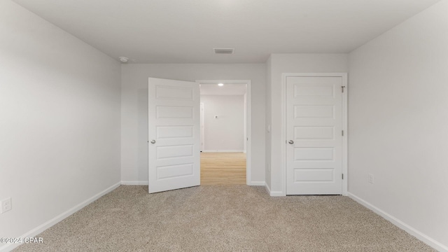 unfurnished room featuring light carpet