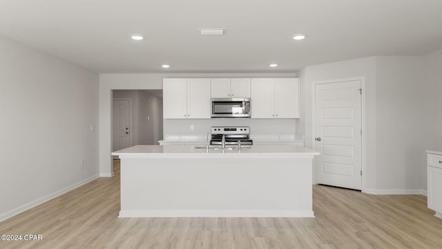 kitchen with appliances with stainless steel finishes, white cabinetry, and an island with sink