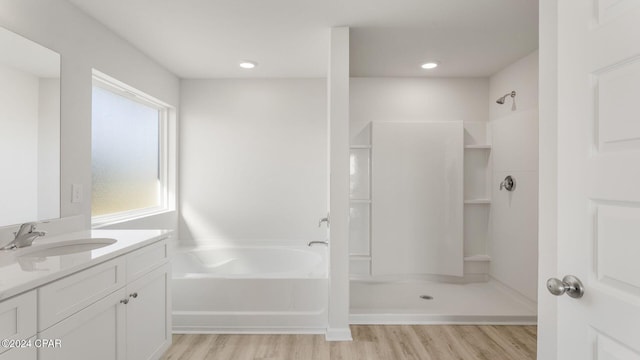 bathroom with separate shower and tub, vanity, and hardwood / wood-style flooring