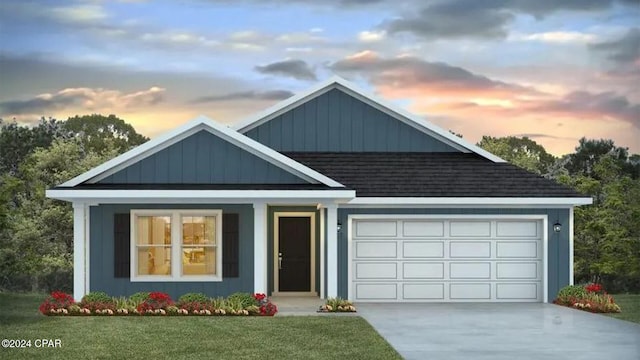 view of front of property with a garage and a yard