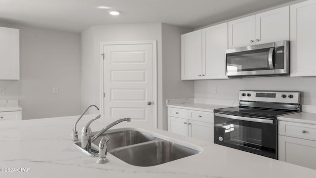 kitchen with white cabinets and appliances with stainless steel finishes