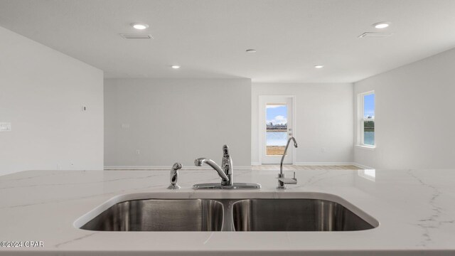 kitchen with light stone counters and sink