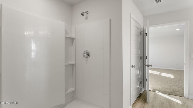 bathroom with hardwood / wood-style floors and walk in shower