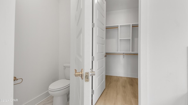 bathroom with toilet and wood-type flooring