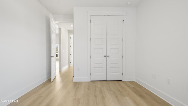 unfurnished bedroom with a closet and light hardwood / wood-style floors