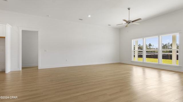 spare room with ceiling fan, light wood-type flooring, and ornamental molding