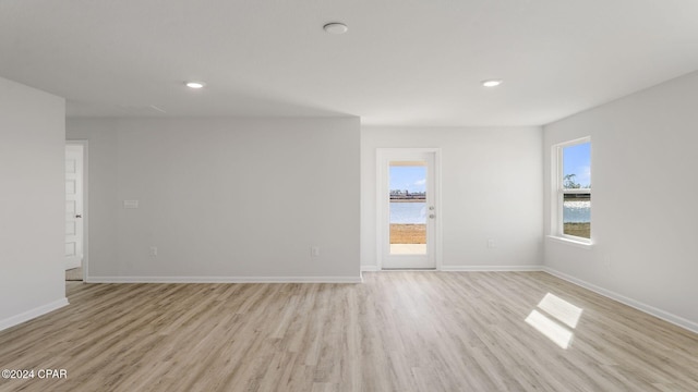 spare room featuring a water view and light wood-type flooring