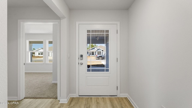 doorway with light wood-type flooring and a healthy amount of sunlight