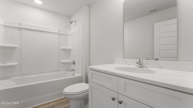 full bathroom featuring washtub / shower combination, vanity, hardwood / wood-style flooring, and toilet