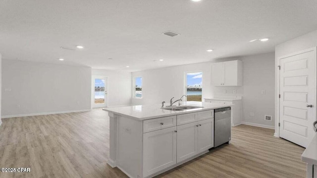 kitchen with sink, light hardwood / wood-style flooring, stainless steel dishwasher, an island with sink, and white cabinets