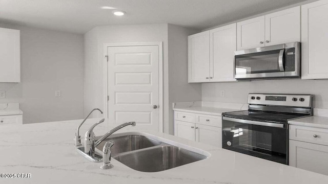 kitchen featuring white cabinetry, electric range oven, and sink